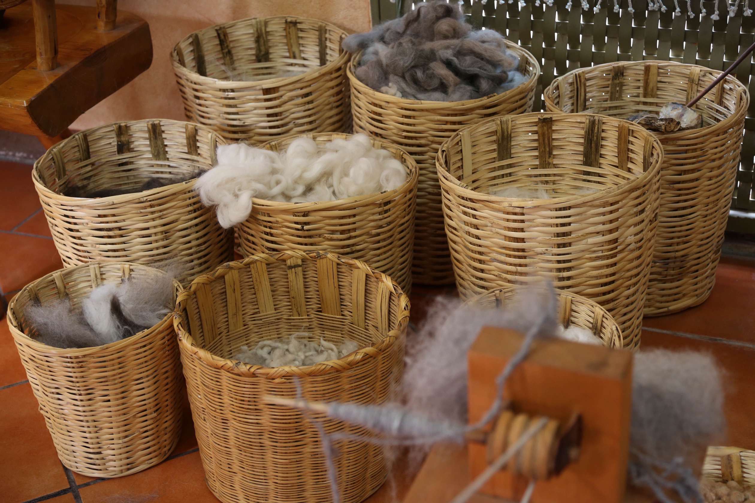 These baskets show the nearly 10 different types of wool, sourced from Mexico and South America that go into this cooperative's rugs.