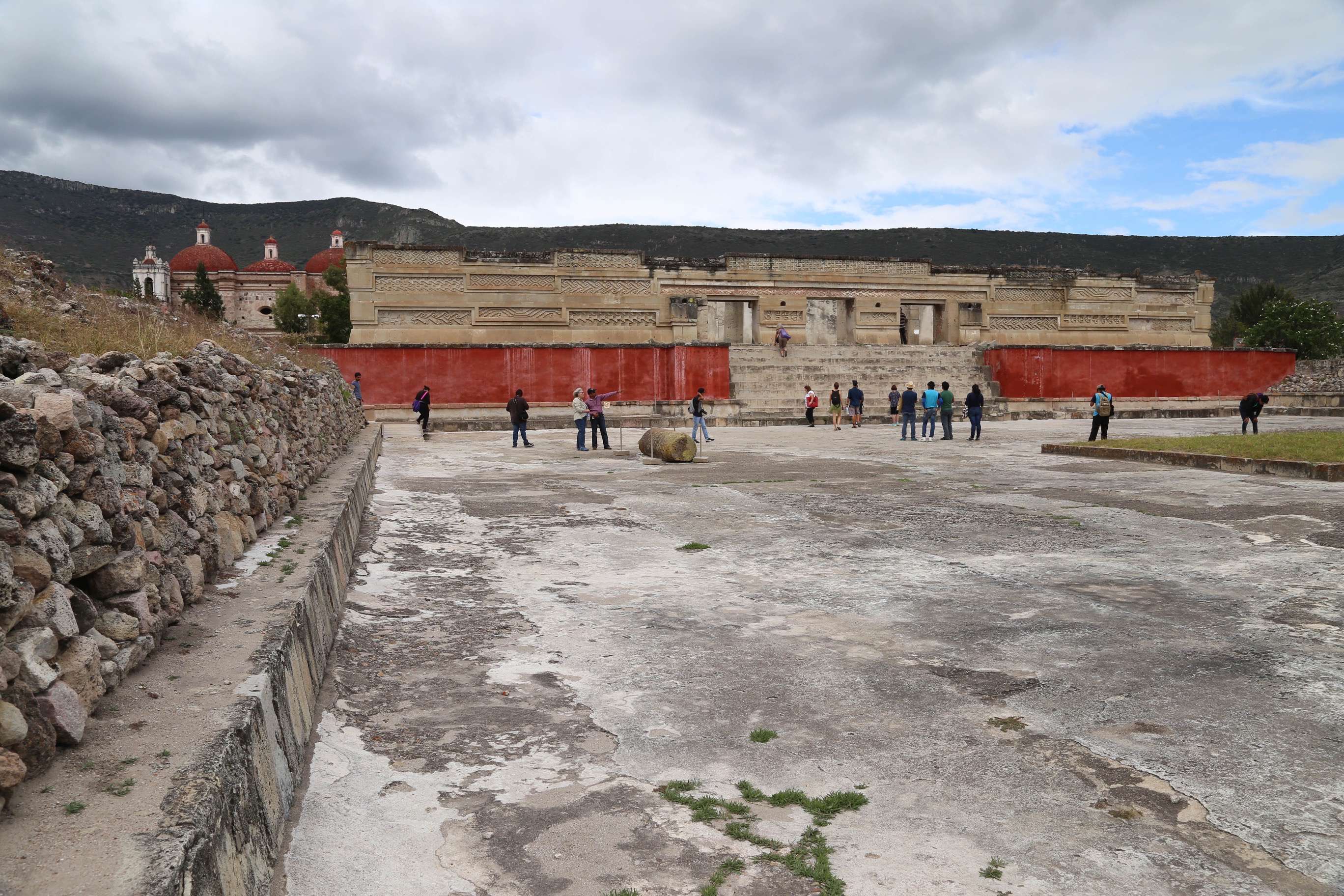 With the Spanish colonial church in the background, left, visitors roam the main courtyard as they take in Mitla.